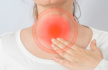 Woman holding her throat with her hand. Neck pain, cold, thyroiditis, thyroid gland.