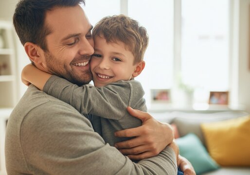 Happy father and son are hugging and smiling at home, enjoying a tender moment together