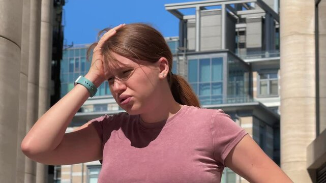 Young woman is suffering because of heat, hot weather, having sunstroke