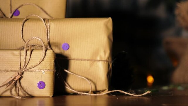 Gift wrapped in brown paper and string with Christmas lights bokeh background