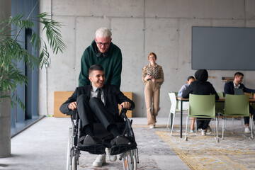 Obraz premium Employee Entertaining Director in a Wheelchair While Rolling Through the Office with Laughter and Joy.