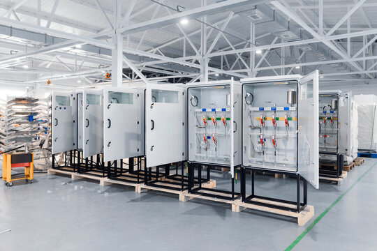 Industrial factory interior with electrical control panels aligned on pallets