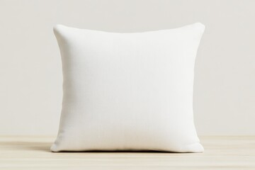 A simple, white decorative pillow sits on a wooden surface, providing a clean and minimalist aesthetic for home decor.