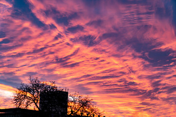 Pink and orange clouds at sunset against a deep blue sky. Abstract natural background for design...