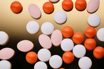 Colorful pills on a golden background.