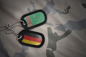 vintage army blank, dog tag with flag of turkmenistan and germany on the khaki texture background....