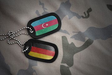 vintage army blank, dog tag with flag of azerbaijan and germany on the khaki texture background....