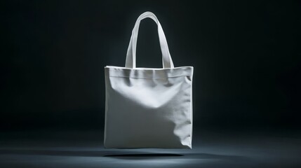 Blank white canvas tote bag mockup floating against a dark background.