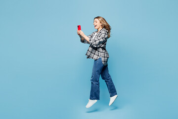 Full body young woman she wears checkered grey shirt casual clothes jump high hold in hand use...