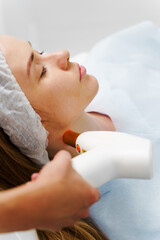 IPL laser rosacea treatment. Rosacea treatment with IPL laser equipment in clinic. Removal vessels in the neck zone with IPL device by beautician.