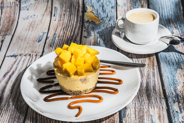 Mango cake with chocolate, accompanied by a coffee.
