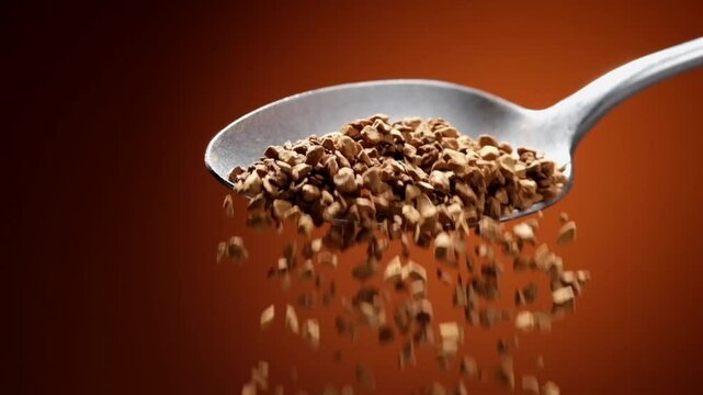 Instant coffee falling from spoon in slow motion, dark background, concept video for commercial
