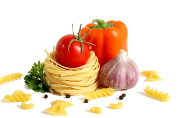 Fresh ripe harvest of vegetables lies on white isolated background with dry pasta before cooking.