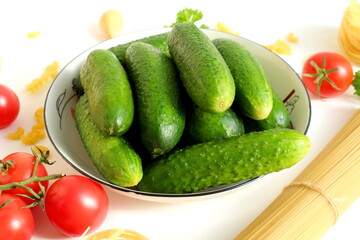 There are many fresh cucumbers in a ceramic white plate.