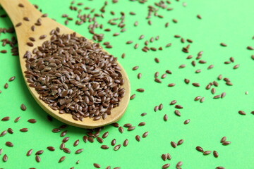 There are flax seeds in a wooden spoon.