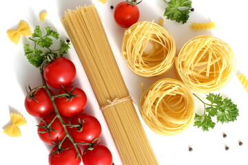 Fresh ripe harvest of vegetables lies on white isolated background with dry pasta before cooking.