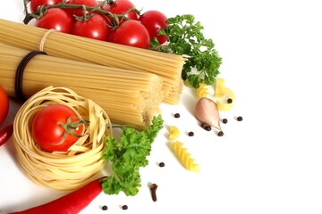 On a white background lie spaghetti and macaroni in the form of a nest with vegetables	