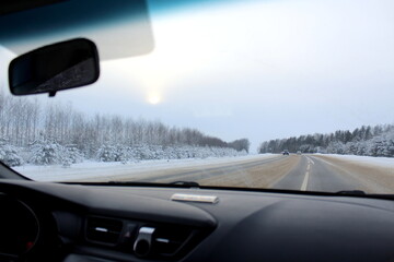 View from the car's interior onto a winter road.