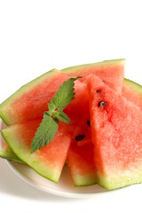 On a white background there is a plate with a bunch of sliced ​​watermelon.