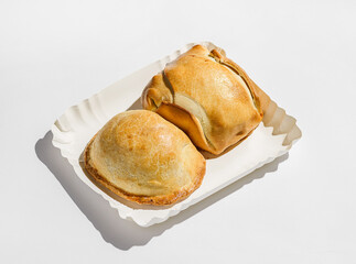 traditional Latin American empanadas on a white cardboard pack for delivery