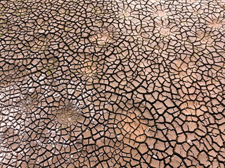 Naklejka premium Cracked dry earth or mud environmental background texture pattern conceptual of drought and natural disaster