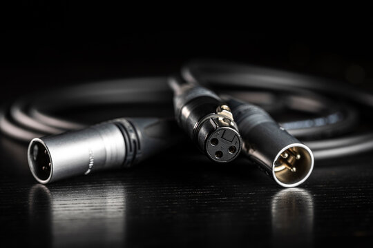 Xlr audio cable lying on dark wooden surface