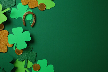 St. Patrick's Day concept with green and gold shamrocks, gold coins, and a horseshoe on a green...