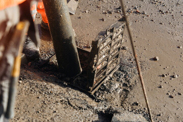 Close-up of Construction workers performing road gully rainwater road drainage repair with vacuum...
