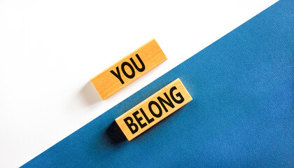 Belonging and you belong symbol. Concept words You belong on beautiful wooden blocks. Beautiful white and blue background. Business belonging and you belong concept. Copy space.