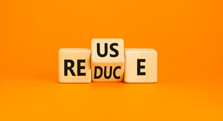 Reuse or reduce symbol. Concept words Reuse Reduce on wooden block. Beautiful orange table orange background. Business reuse or reduce concept. Copy space.