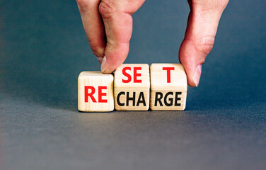 Reset and recharge symbol. Concept words Reset Recharge on beautiful wooden block. Beautiful grey...