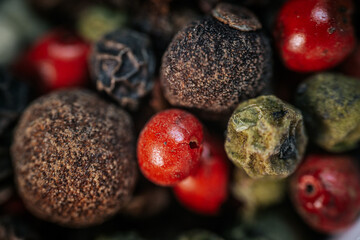 Close-up macro of colorful peppercorn mix featuring black, white, red, and green peppercorns. A vibrant blend of textures and spices, ideal for culinary and seasoning themes.