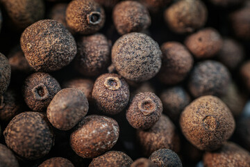 Close-up macro view of dried allspice berries, showcasing their textured surface and earthy brown tones. Ideal for culinary and spice-related imagery.