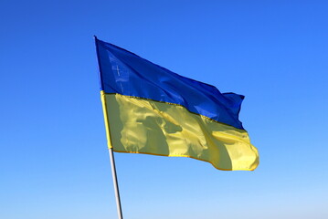 Ukraine flag large national symbol fluttering in blue sky. Large yellow blue Ukrainian state flag, Dnipro. Concept of heroic struggle of Ukrainian people against Russian war
