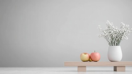 Balance proportion wellness concept. A minimalist display of apples and flowers on a wooden shelf against a neutral background.