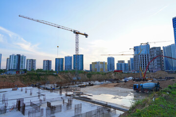 Foundation slab for monolithic reinforced skyscraper. Preparing Formwork for First Floor Slab on building сonstruction. Formworks and pouring concrete. Tower crane and cranes on construction site.