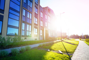 Obraz premium Green lawn with trees near residential building. Modern complex of apartment residential building. Landscape design. Landscaping for urban spaces. Lawn at Condo house complex in city. Condominium.