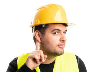 Close-up of constructor touching ear as listening gesture