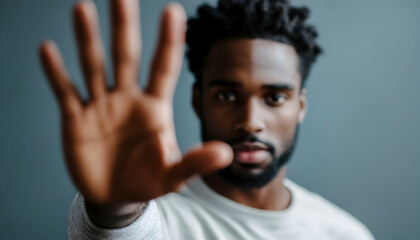 A man holding his hand up to block something from the camera, showing an expression of resistance