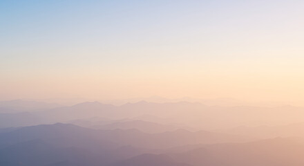 Obraz premium Serene Sunset Over Misty Mountain Ranges