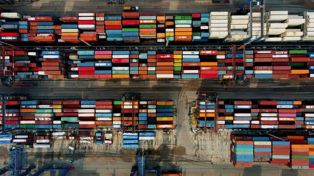 Of a bustling container terminal port, showcasing a container ship loading and unloading freight. Thousands of colorful shipping containers fill the industrial area for global trade.