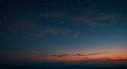 Fototapeta premium Starry Night Sky Over Silhouetted Mountains at Sunset