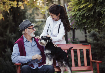 Nurse in white coat taking care of senior man in park