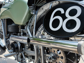 Detailed shot of an old German racing motorcycle from the 1950s, engine with chrome exhaust system,...
