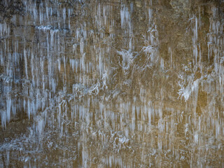 Eiszapfen an einer gefrorenen Felswand in einem Steinbruch