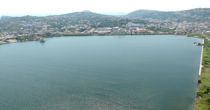 Aerial view of Fusaro Lake located in Bacoli, in the metropolitan city of Naples, Campania, Italy. It is separated from the sea by a narrow coastal strip. It was known by the Latins as Acherusia Palus