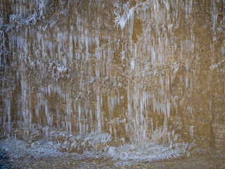 Eiszapfen an einer gefrorenen Felswand in einem Steinbruch