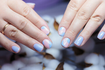 Female hands with a purple colour nails close-up. Nail design. Artistic manicure with a purple nail polish