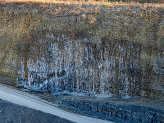 Eiszapfen an einer gefrorenen Felswand in einem Steinbruch