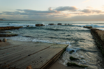 Paisaje marítimo de amanecer sobre el antiguo embarcadero del saladar en la playa de Agua Amarga,...